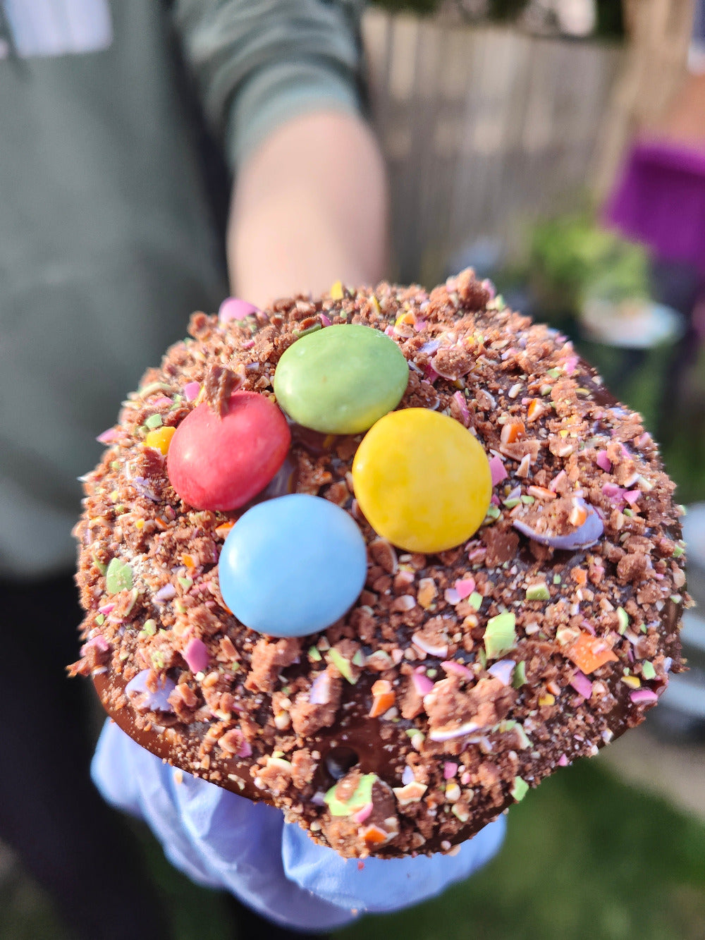 A mixed milk Choc chip dough with crush smartie -- Stuffed with more crush smartie chocolates, white chocolate , and topped chocolate ganache and smartie crush 
