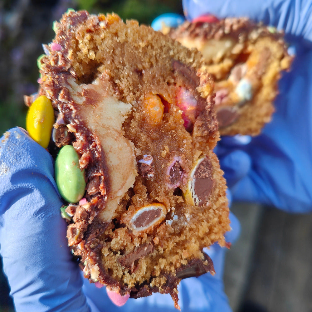 A mixed milk Choc chip dough with crush smartie -- Stuffed with more crush smartie chocolates, white chocolate , and topped chocolate ganache and smartie crush